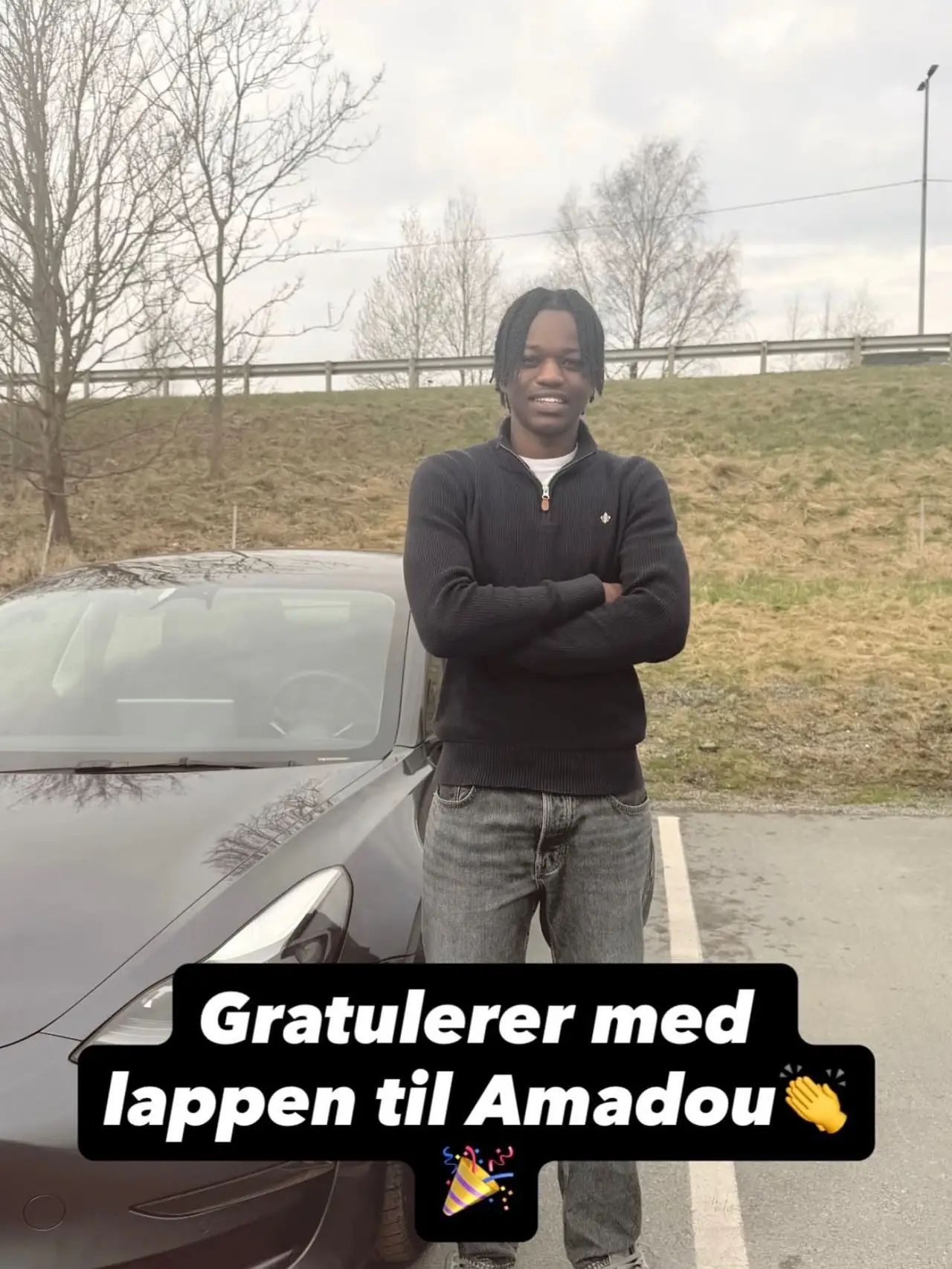 Amadou ved skolebilen etter bestått førerprøve