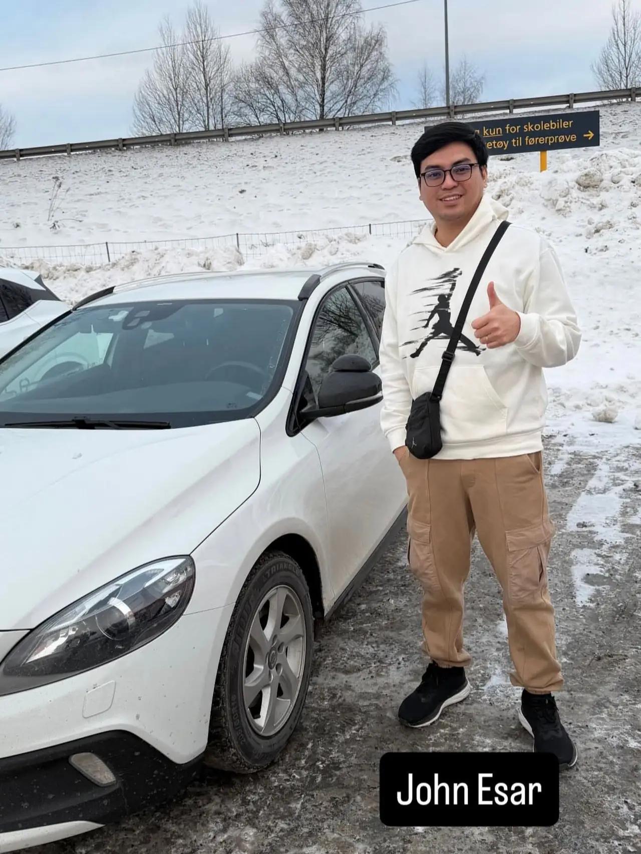 John Esar ved skolens Volvo etter bestått førerprøve