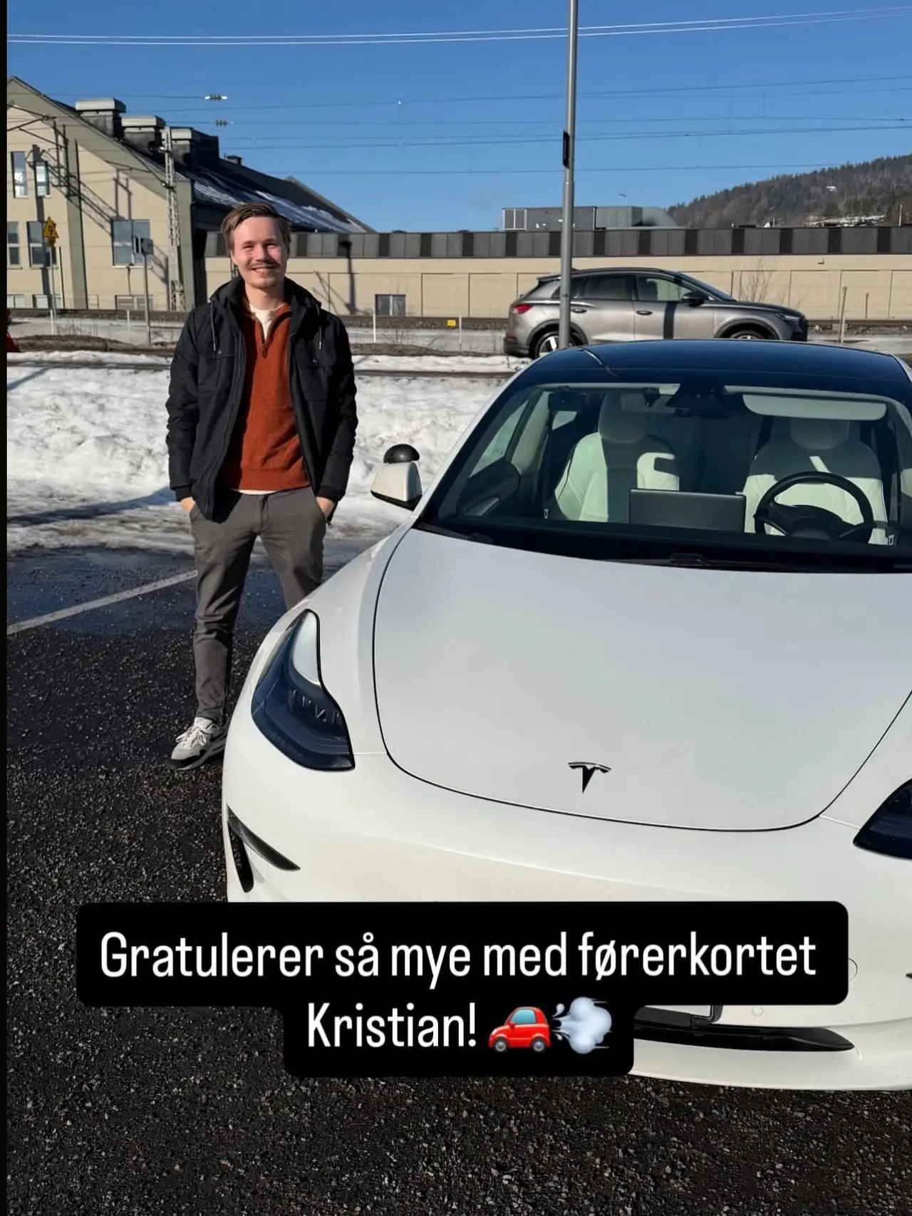 Kristian foran skolens Tesla etter bestått førerprøve