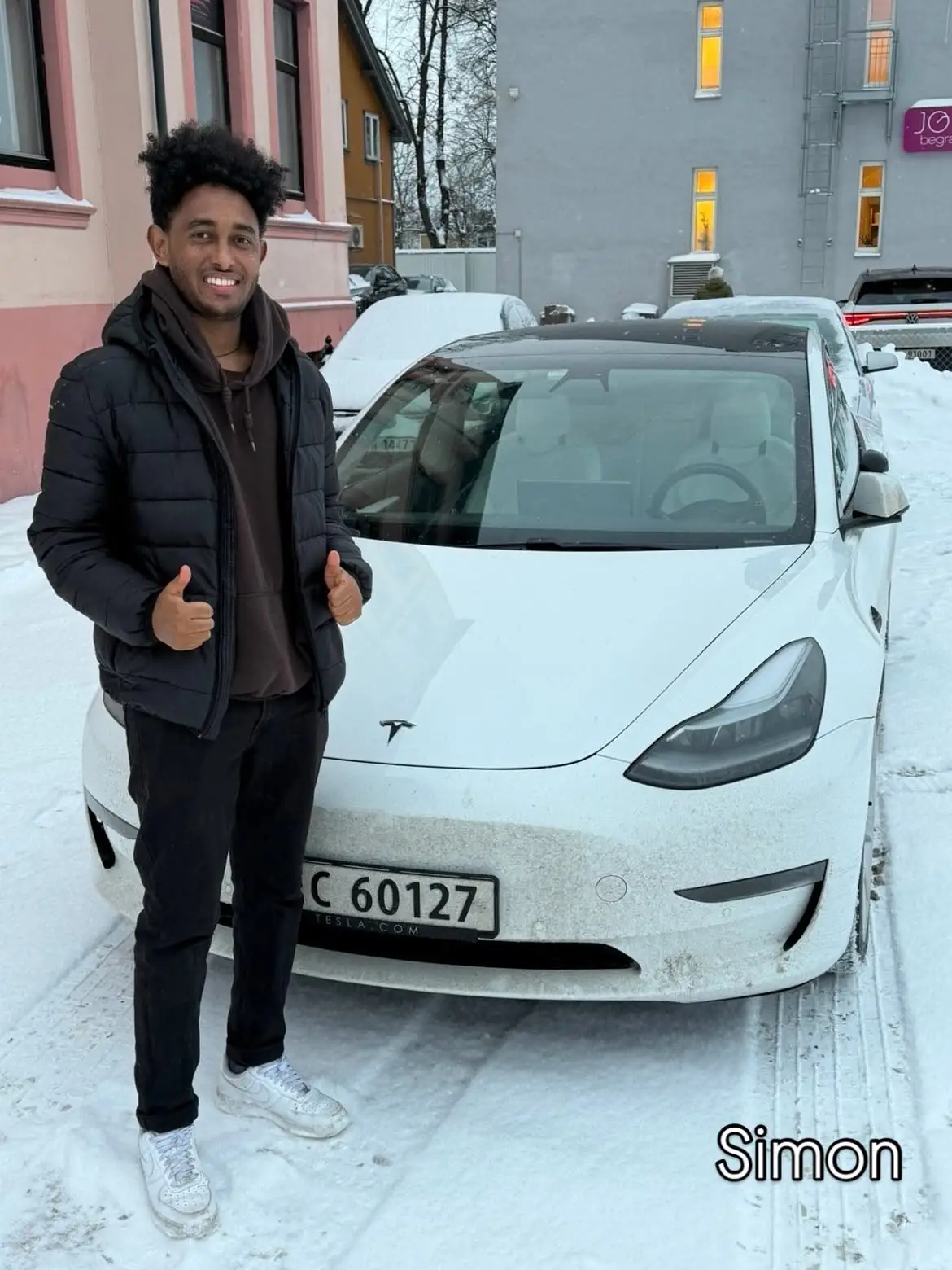 Simon foran skolens Tesla etter bestått førerprøve